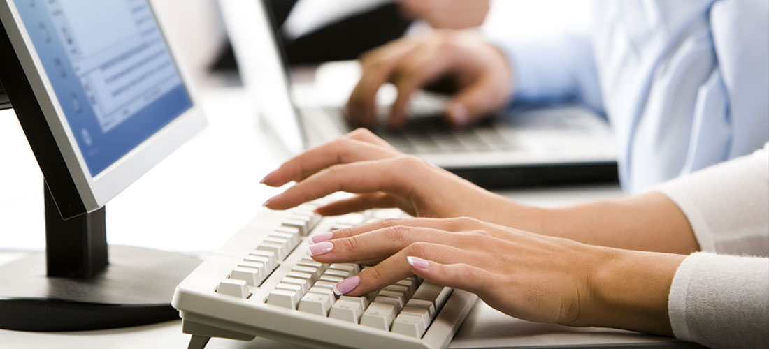 image of people typing at a computer keyboard